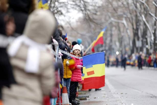 Imagine de la parada militară care are loc de 1 decembrie, cu ocazia Zilei Naţionale a României. O fată flutură drapelul