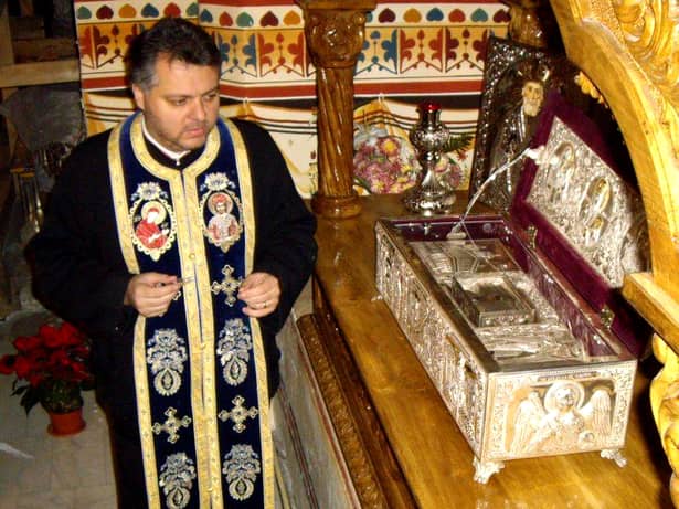 Preotul Emil Nedelea Cărămizaru lângă racla cu mâna Sfântului Nicolae, aflată la biserica Sfântul Gheorghe Nou din București, chiar la kilometrul zero al României