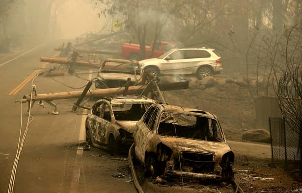 Dezastrul lăsat în urmă de incendiile din California. Maşinile sunt distruse pe marginea drumului, stâlpii de elecricitate sunt picaţi pe şosea