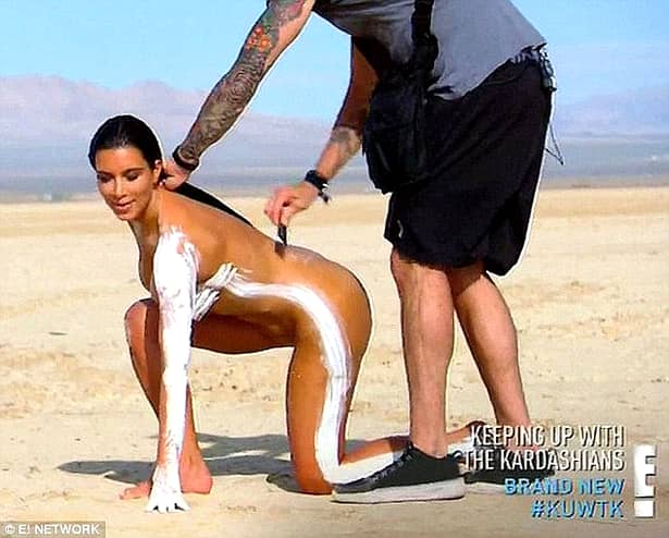 Kim Kardashian goală, stând în genunchi pe nisip