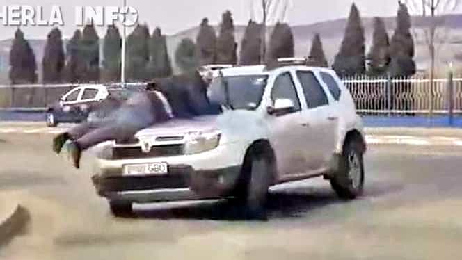 Se întâmplă în România! Bărbat agăţat de capota unui Duster învârtit prin intersecţie! Video