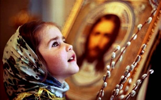 Cum va fi modificat textul rugăciunii ”Tatăl nostru”. O fetiţă este fotografiată în biserică în timp ce se roagă