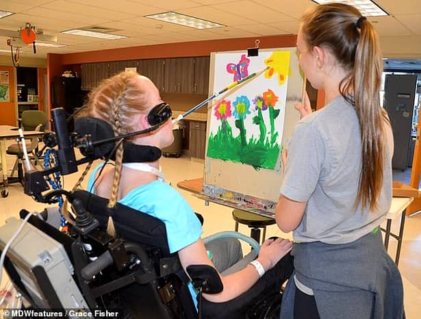 O tânără de 21 de ani, paralizată de la gât în jos, pictează și cântă la pian cu gura – VIDEO/ FOTO